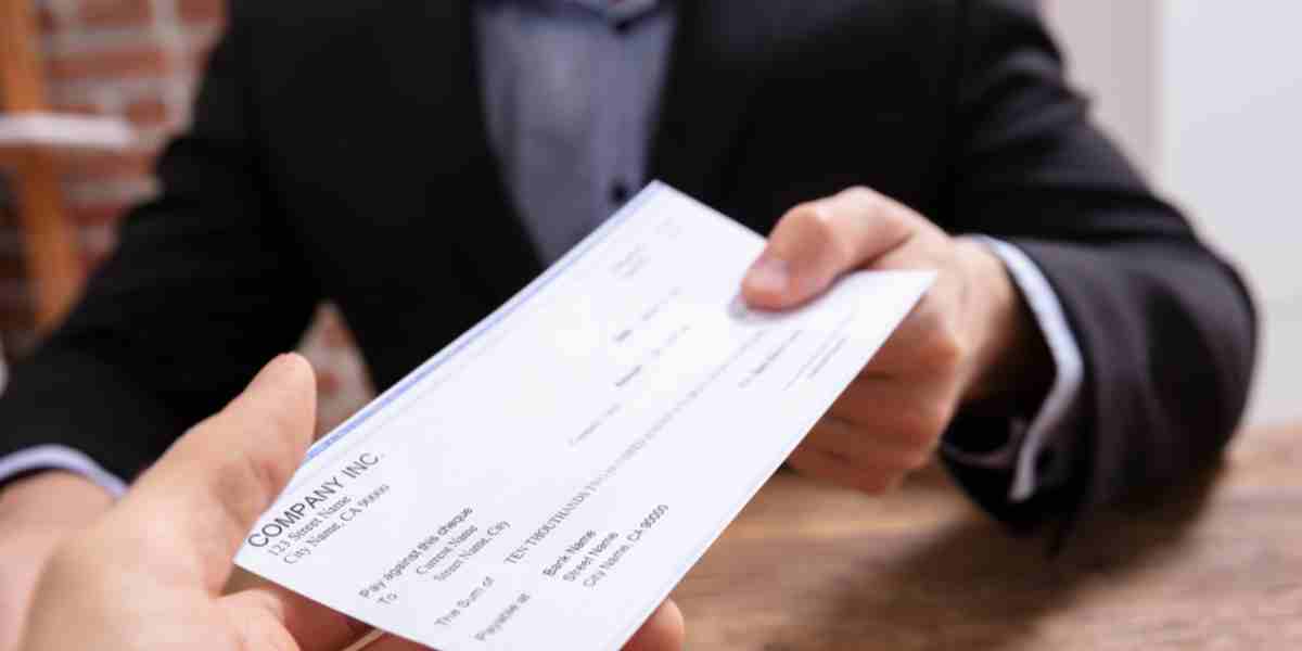 Close-up of a blank bank cheque with signature line highlighted, placed on a desk with a pen beside it