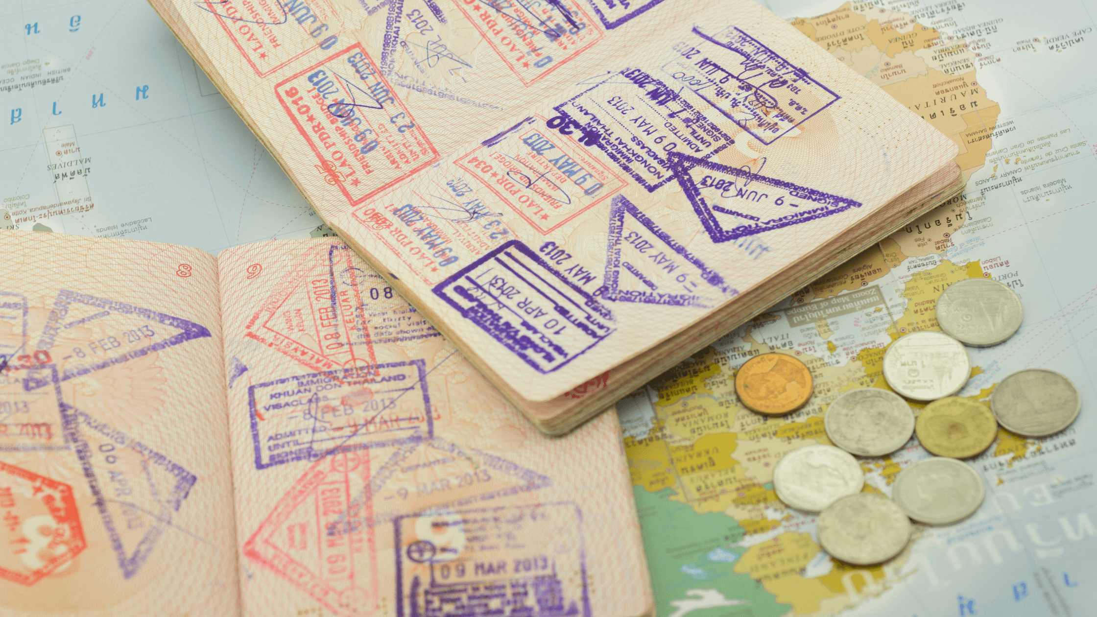 Close-up of a UAE passport lying on a desk next to an Emirates ID card and a laptop displaying a government portal login screen