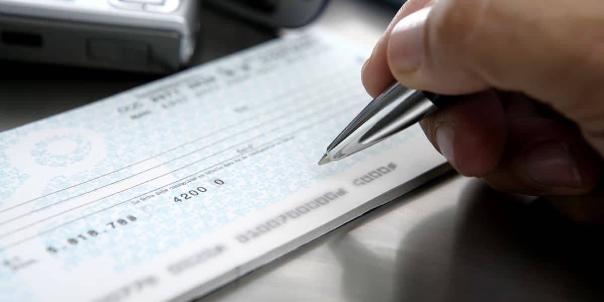 Close-up of a dishonored bank cheque stamped with insufficient funds notice on a desk with UAE currency and legal documents