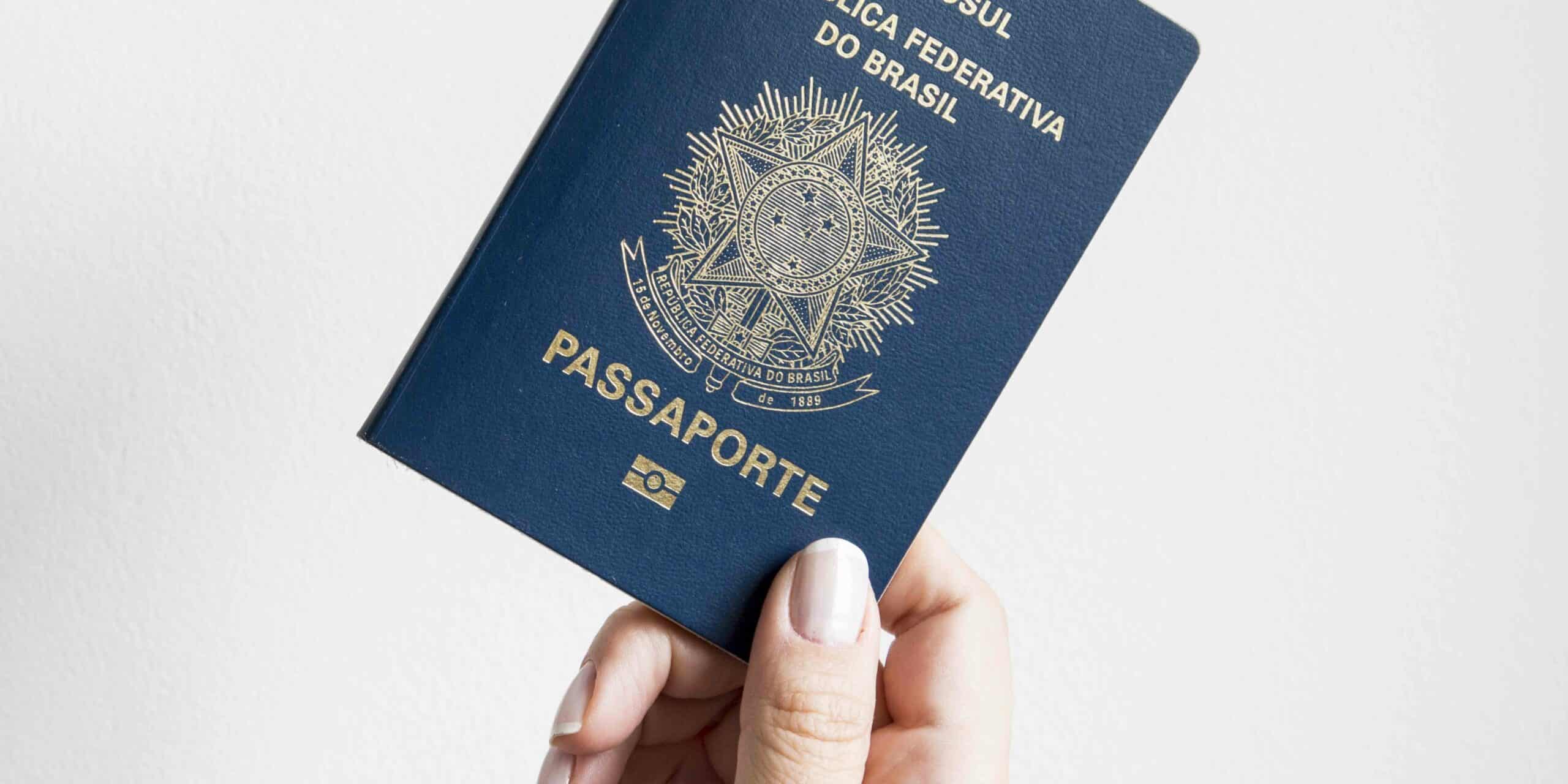 Close-up of a UAE passport placed on a desk next to a computer screen displaying an official government portal interface for travel ban