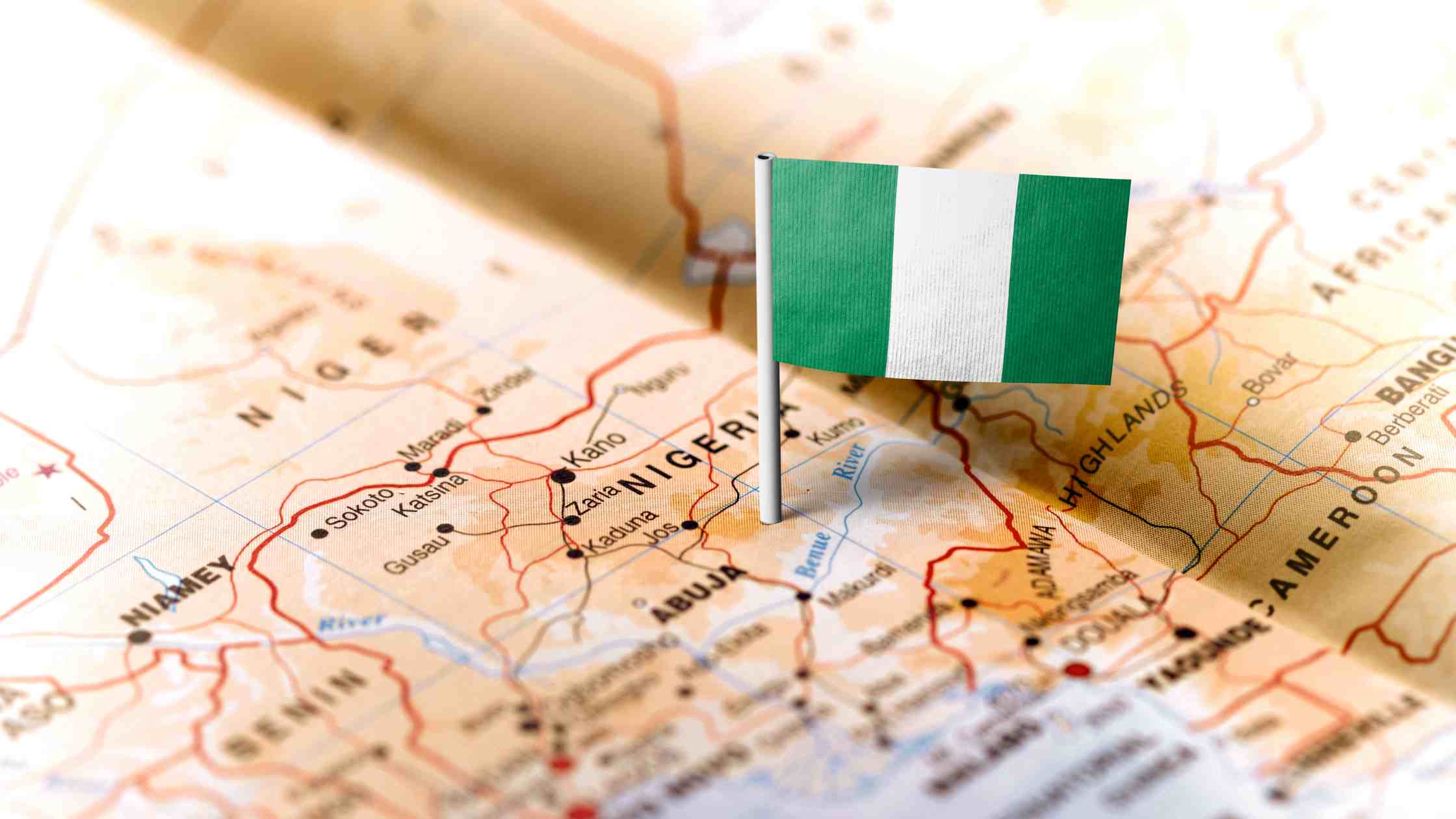Nigerian passport alongside UAE visa application documents and Emirates Airlines boarding pass on an office desk