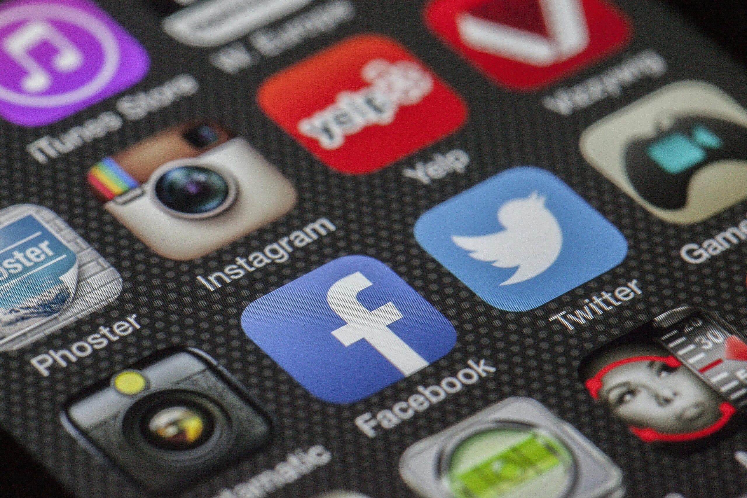 Close-up of a smartphone displaying a social media feed with Arabic text, placed on a desk beside legal documents and a gavel