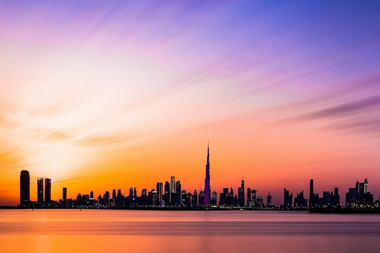 Modern Dubai skyline with government buildings and official documentation visible in foreground